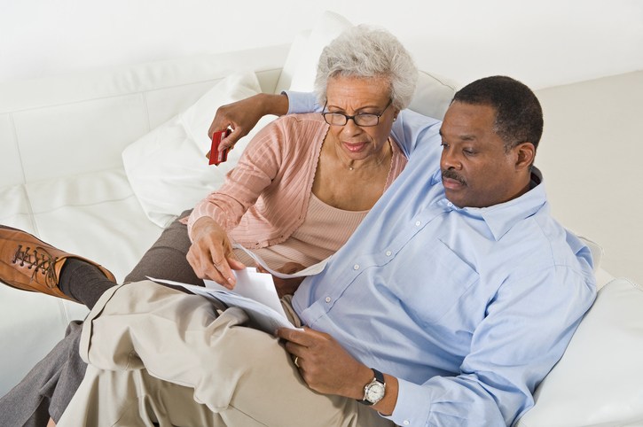 Senior couple on couch with paperwork